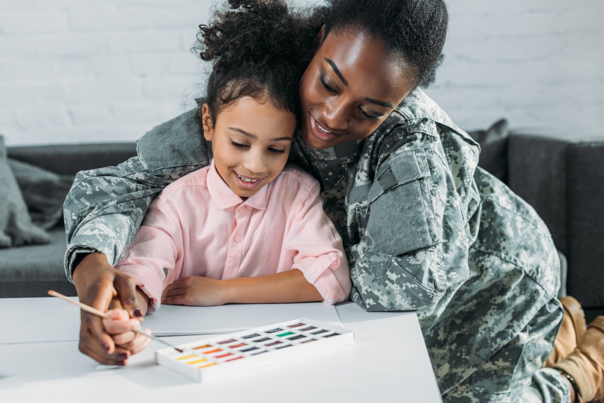 femal soldier painting with daughter