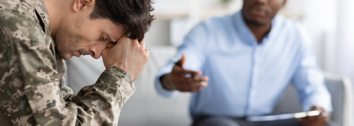 Distressed young man soldier attending therapy session with psychiatrist