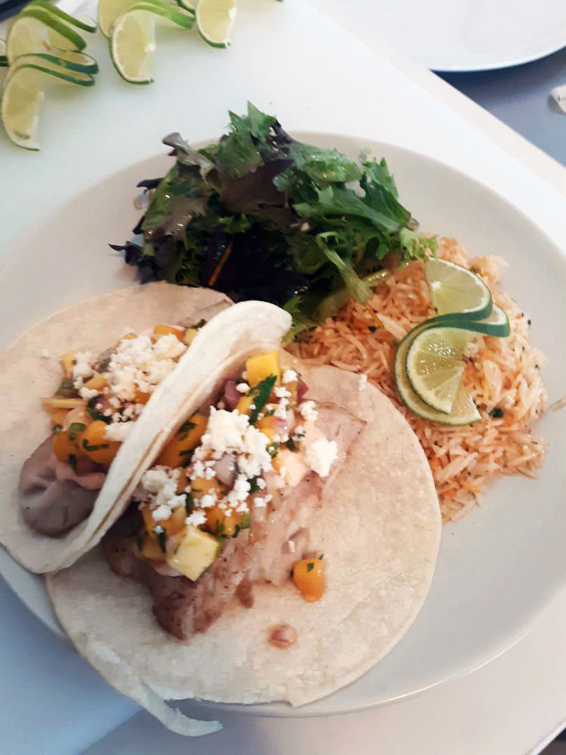Grilled fish tacos with mango salsa, cilantro-lime rice, and side greens.