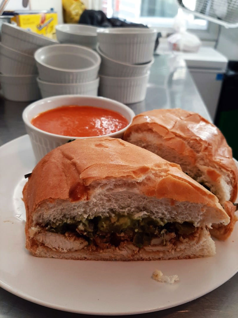 Pollo asado torta stuffed with avocado and onions, paired with creamy roasted-pepper tomato bisque.