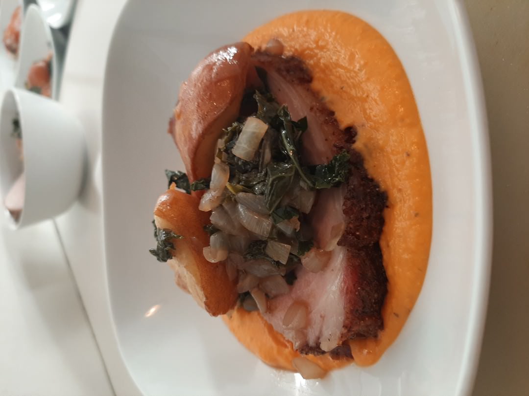 Crispy roasted pork belly with braised kale and onions on roasted yam-pear puree.